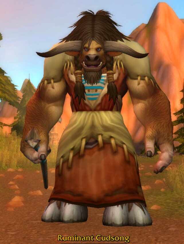 Ruminant Cudsong, a tan-brown tauren with long braided brown hair, a braided beard and horns that curve down and then up, wearing a red and khaki robe fringed with claws over a blue-striped shirt and holding a small knife, standing on a dirt road in Mulgore with orange mesas behind him